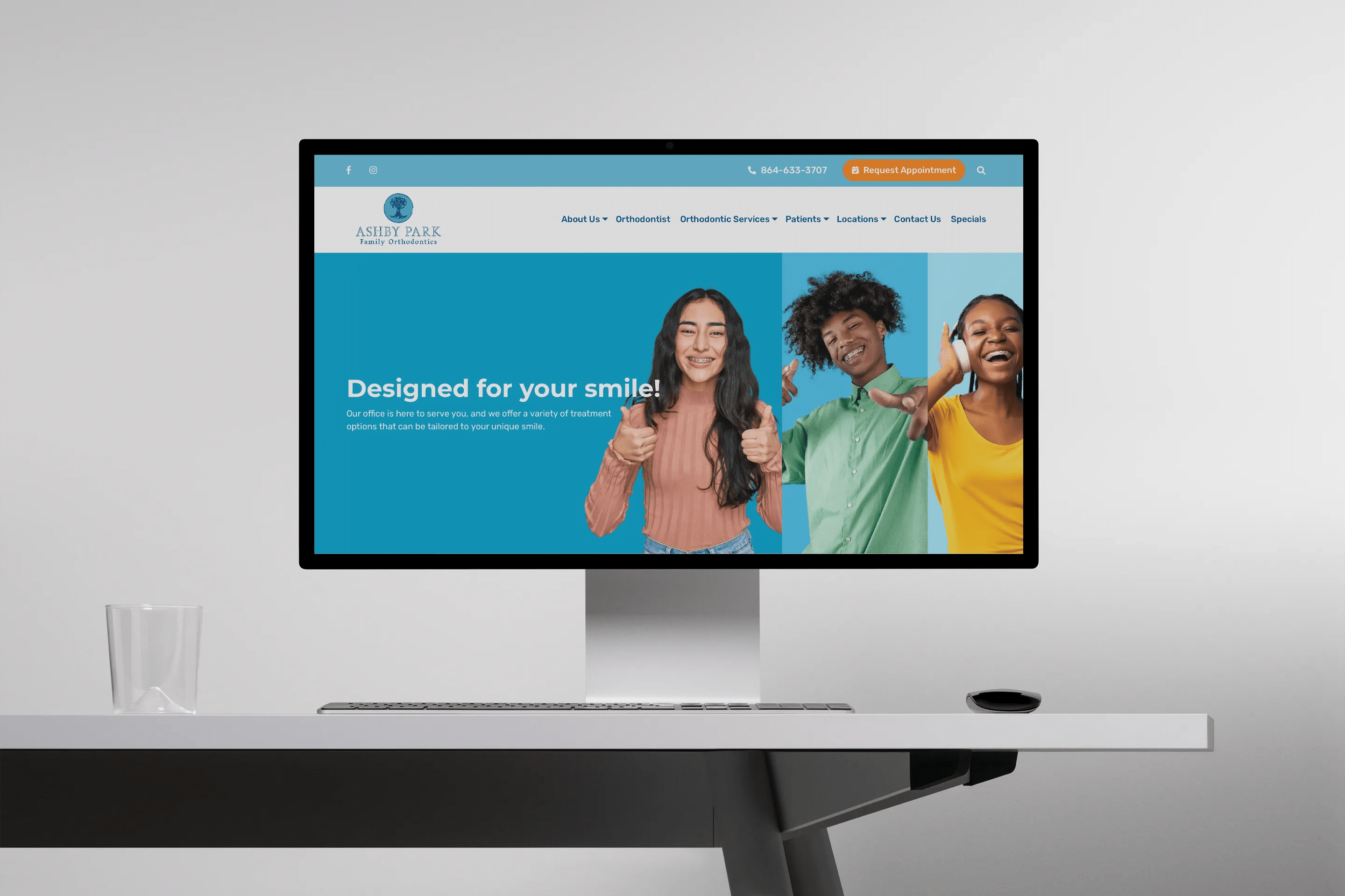 A desktop screen displays the homepage of Ashby Park Family Orthodontics. The banner shows three smiling young individuals, each with braces, against vibrant backgrounds, accompanied by the tagline “Designed for your smile!” promoting customized orthodontic care.