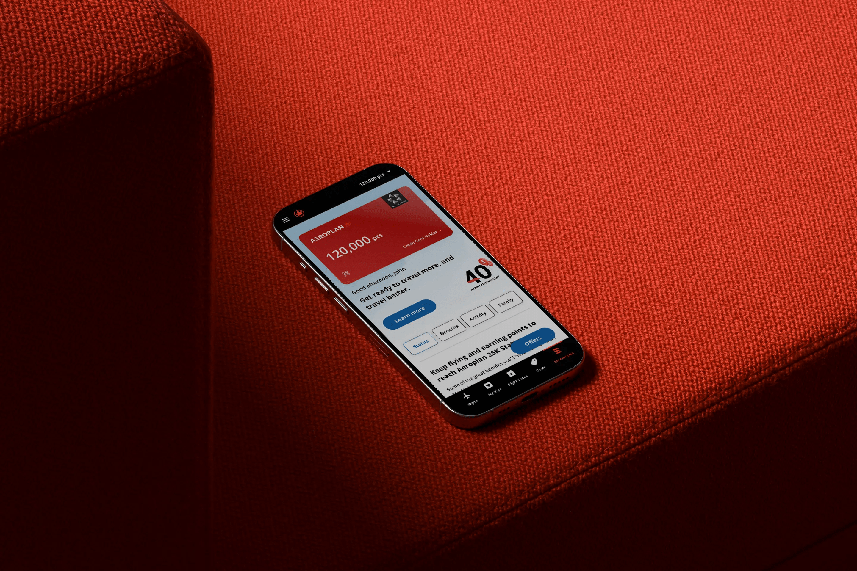 A tablet resting on a red fabric surface displays the Aeroplan eStore gift card redemption page. The screen shows a $500 Air Canada gift card with options to select quantity and format (physical), along with a green tag indicating it’s on sale for 50,000 points.